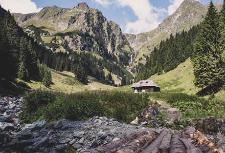 Stream, footbridge and hut in mountain valley